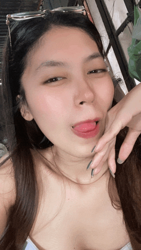 a woman wearing sunglasses sticks her tongue out while making a funny face