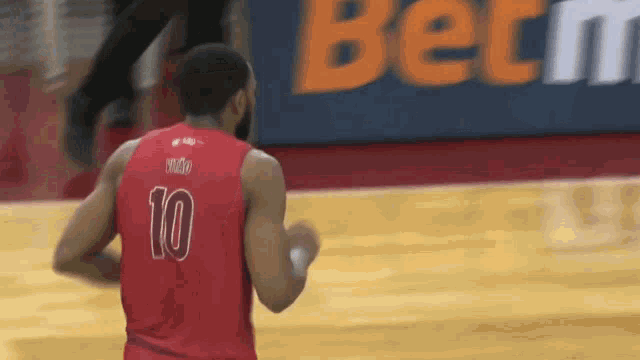 a basketball player wearing a red jersey with the number 10 on the back