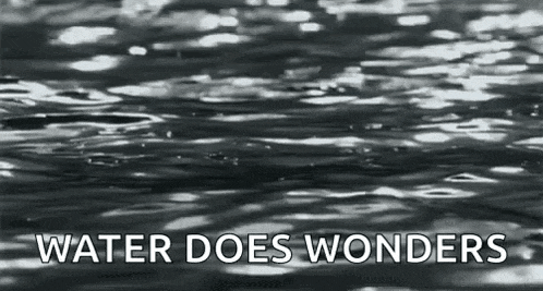 a black and white photo of a body of water with the words `` water does wonders '' written above it .