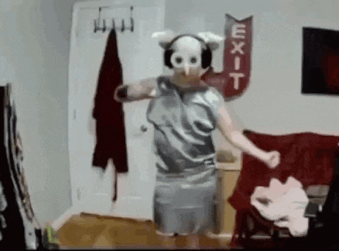 a person wearing a pig mask and headphones is dancing in a living room .