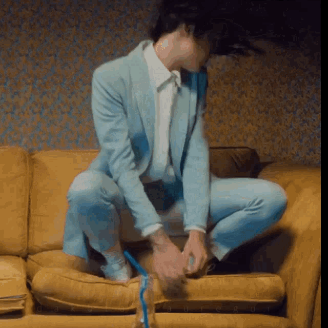 a man in a suit is sitting on a couch