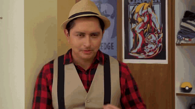 a man wearing a plaid shirt and a hat stands in front of a poster that says edge