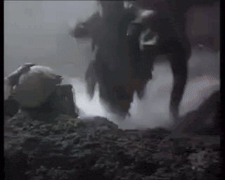 a person is standing on a rock in a dark room with smoke coming out of it .