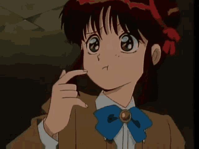 a girl with red hair and a blue bow tie is making a funny face .