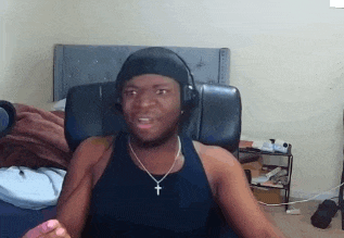 a man wearing headphones and a necklace with a cross on it is sitting in a chair .