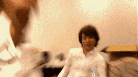 a blurry picture of a man sitting on a couch .