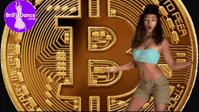 a woman is dancing in front of a large bitcoin
