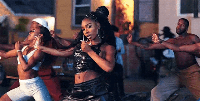 a woman is dancing in front of a group of people .