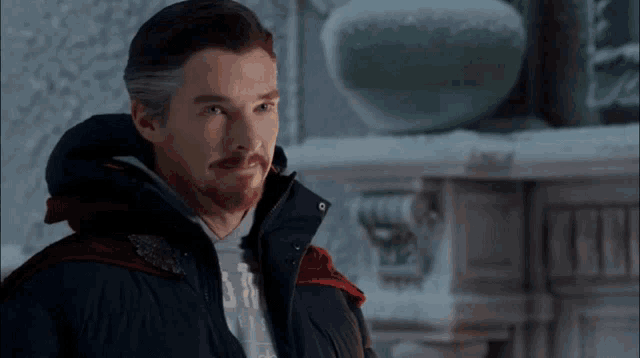 a man with a beard is wearing a jacket with a red hood