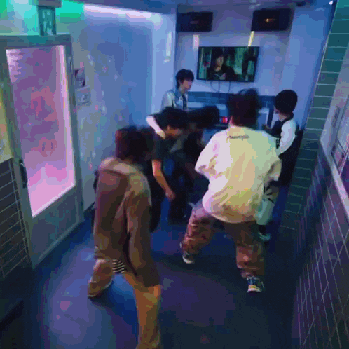 a group of people are dancing in a hallway and one of them is wearing a white shirt that says supreme on the back