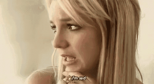 a woman is crying and holding her hand to her face .