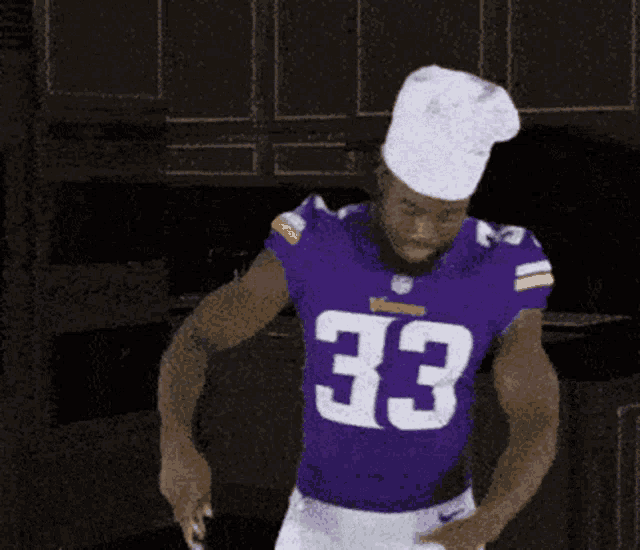 a football player wearing a purple jersey with the number 33