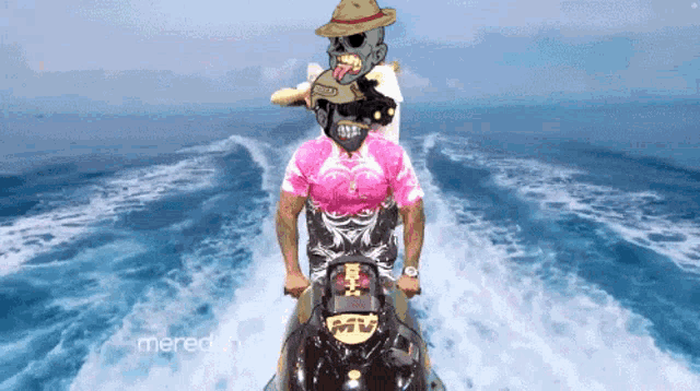 a man in a pink shirt rides a jet ski in the ocean