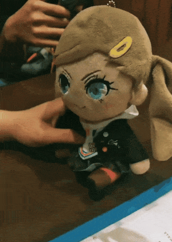 a person petting a stuffed doll that has the letter o on it