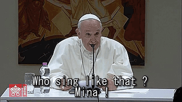 a man sitting at a table with a microphone and the words who sing i like that mina