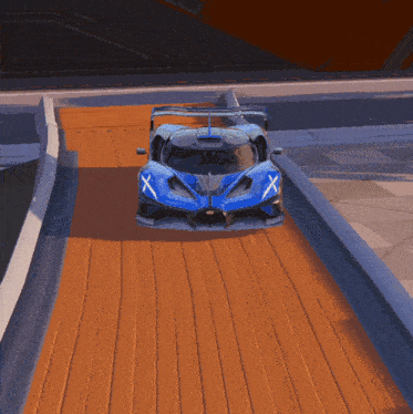 a blue sports car with an x on the side is driving down a track