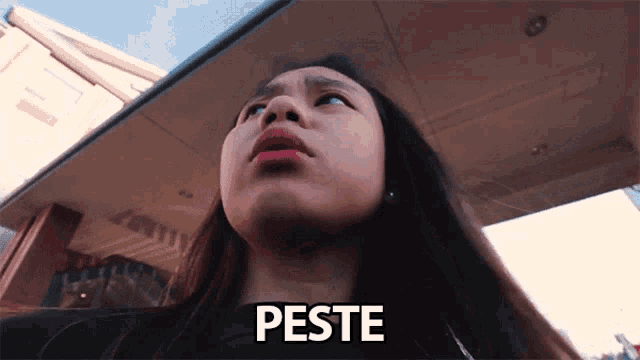 a woman is looking up and the word peste is above her head