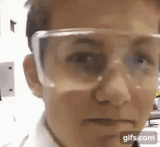 a woman wearing safety goggles is looking at the camera .