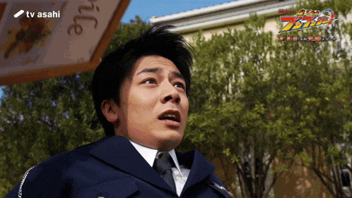 a man in a police uniform stands in front of a tv asahi logo