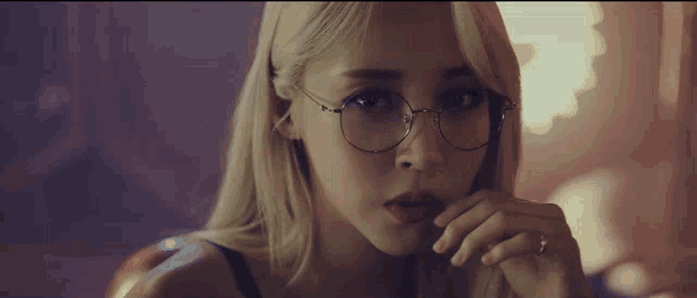 a woman wearing glasses and a ring on her finger