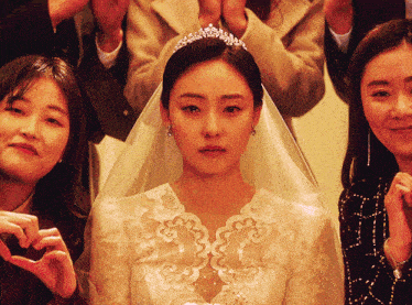 a woman in a wedding dress with a tiara on her head is surrounded by other women