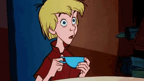 a cartoon boy is sitting at a table holding a blue cup of tea .