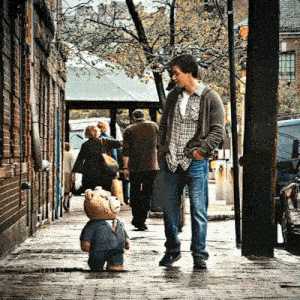 a man walking down a sidewalk with a teddy bear in a suit