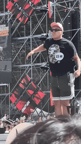a man stands in front of a crowd wearing a black shirt that says " japan " on it