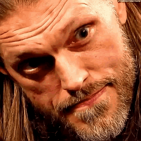 a close up of a man 's face with a beard making a funny face .
