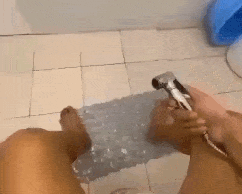 a person is taking a shower with their feet on a mat