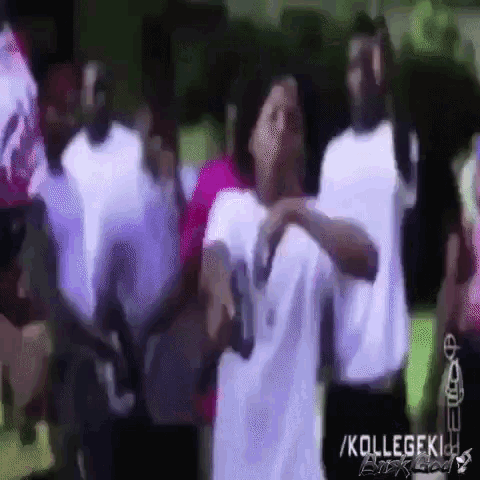 a group of people are dancing in front of a sign that says ' kollegeki '