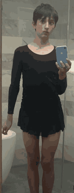 a young man taking a picture of himself in a bathroom mirror