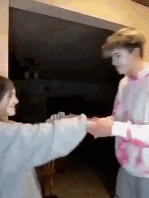 a man and a woman are standing next to each other holding hands .