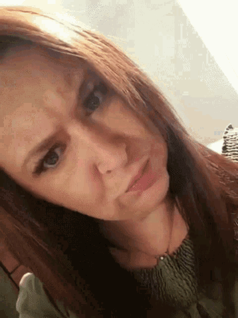 a close up of a woman 's face with a serious look on her face .