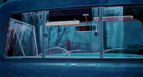 a blue car with a rear view mirror on the back window