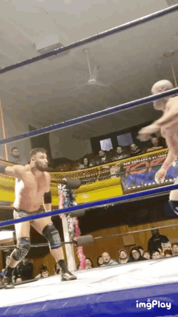 a man in a wrestling ring with a sign that says imgplay on it