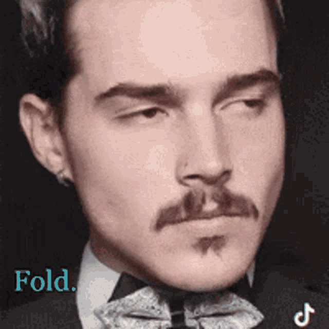 a man with a mustache is wearing a tuxedo and bow tie ..