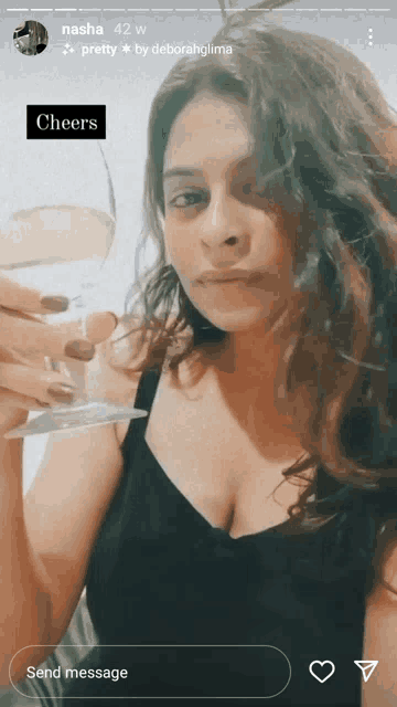 a woman in a black top is holding a glass of wine and says cheers on the bottom