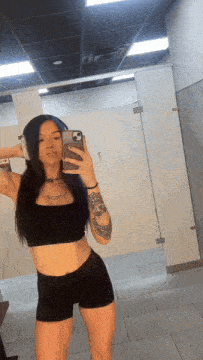 a woman taking a selfie in a bathroom with headphones on
