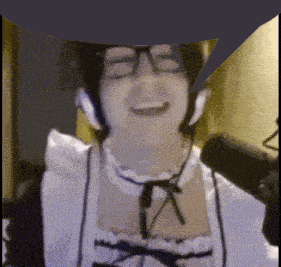 a woman wearing headphones and a maid costume is smiling