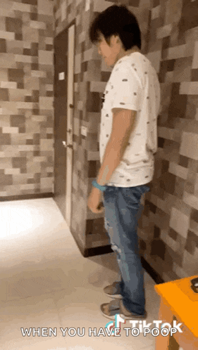 a man is standing in a hallway with the words when you have to poop written on the bottom