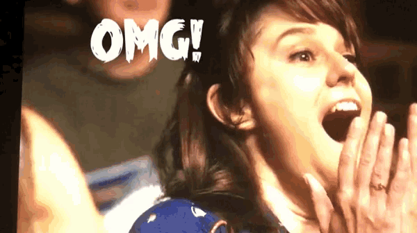 a woman with her mouth open and the word omg on the screen behind her
