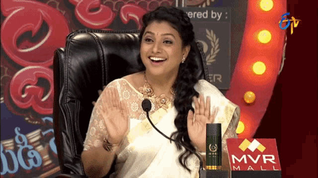 a woman sitting in front of a mvr mall podium