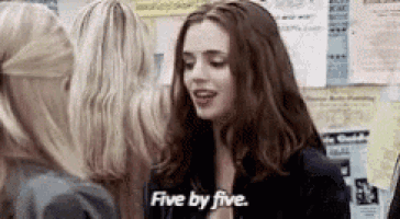 a woman is talking to another woman in a room and says five by five .