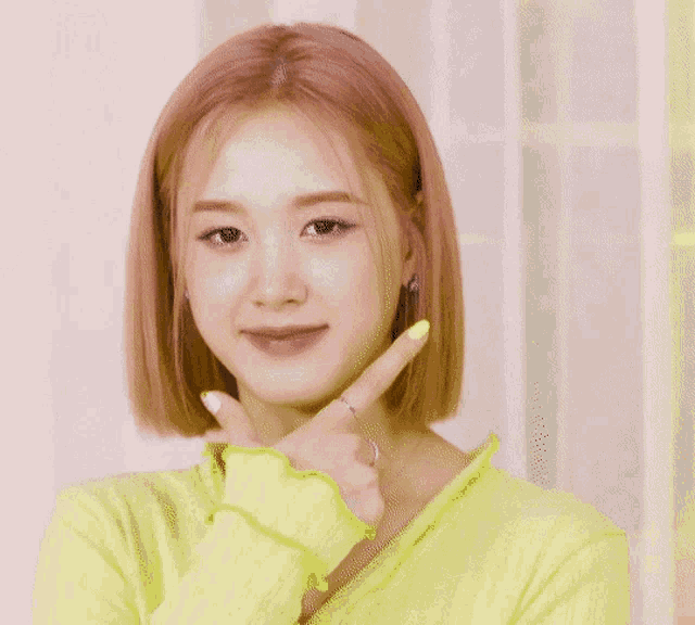 a woman with short pink hair is wearing a neon yellow shirt