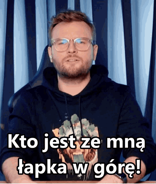 a man wearing glasses and a hoodie says kto jest ze mna tapka w gorę