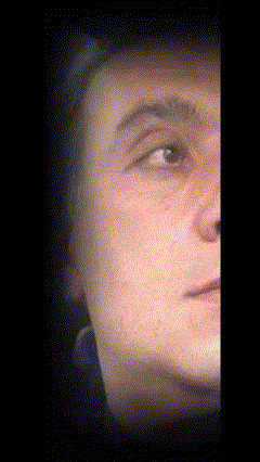 a close up of a man 's face with a black background behind him