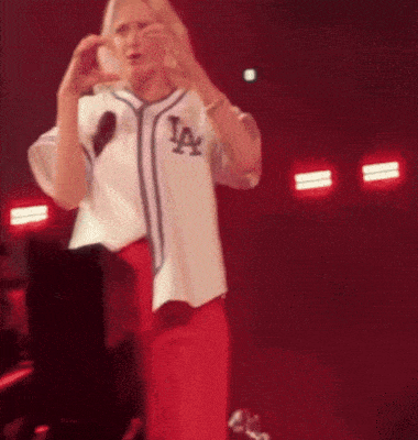 a woman wearing a la jersey making a heart shape with her hands