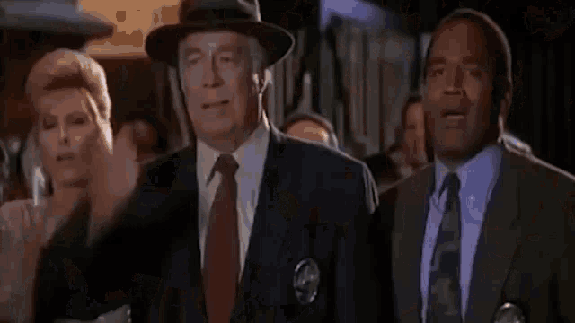 a group of three men in suits and ties are standing next to each other .