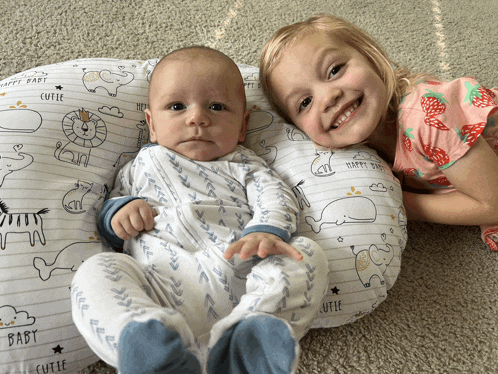a baby is laying on a pillow that says happy baby